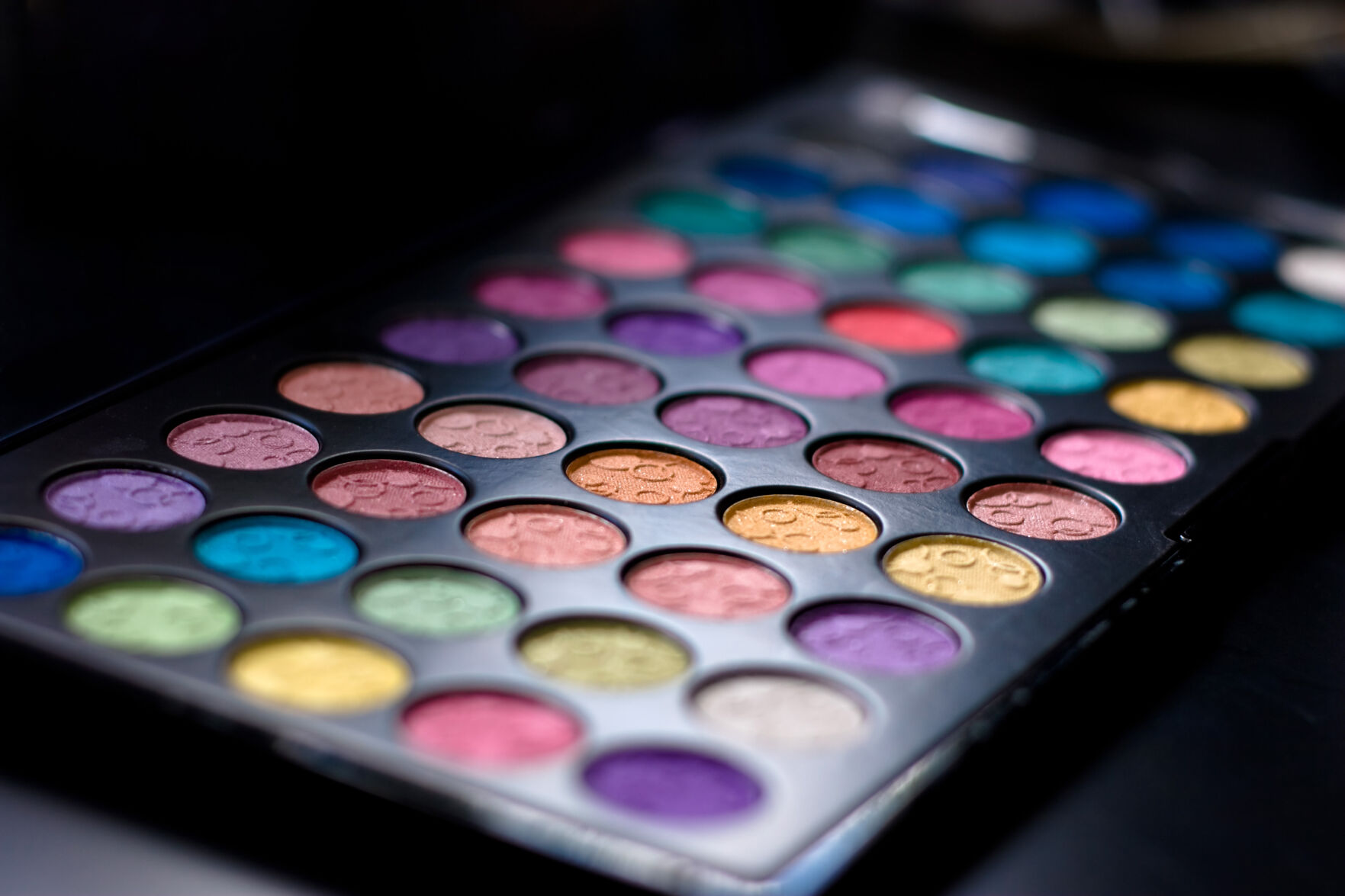 Close up of a colorful assortment of eye shadow cosmetics. Shallow depth of field.